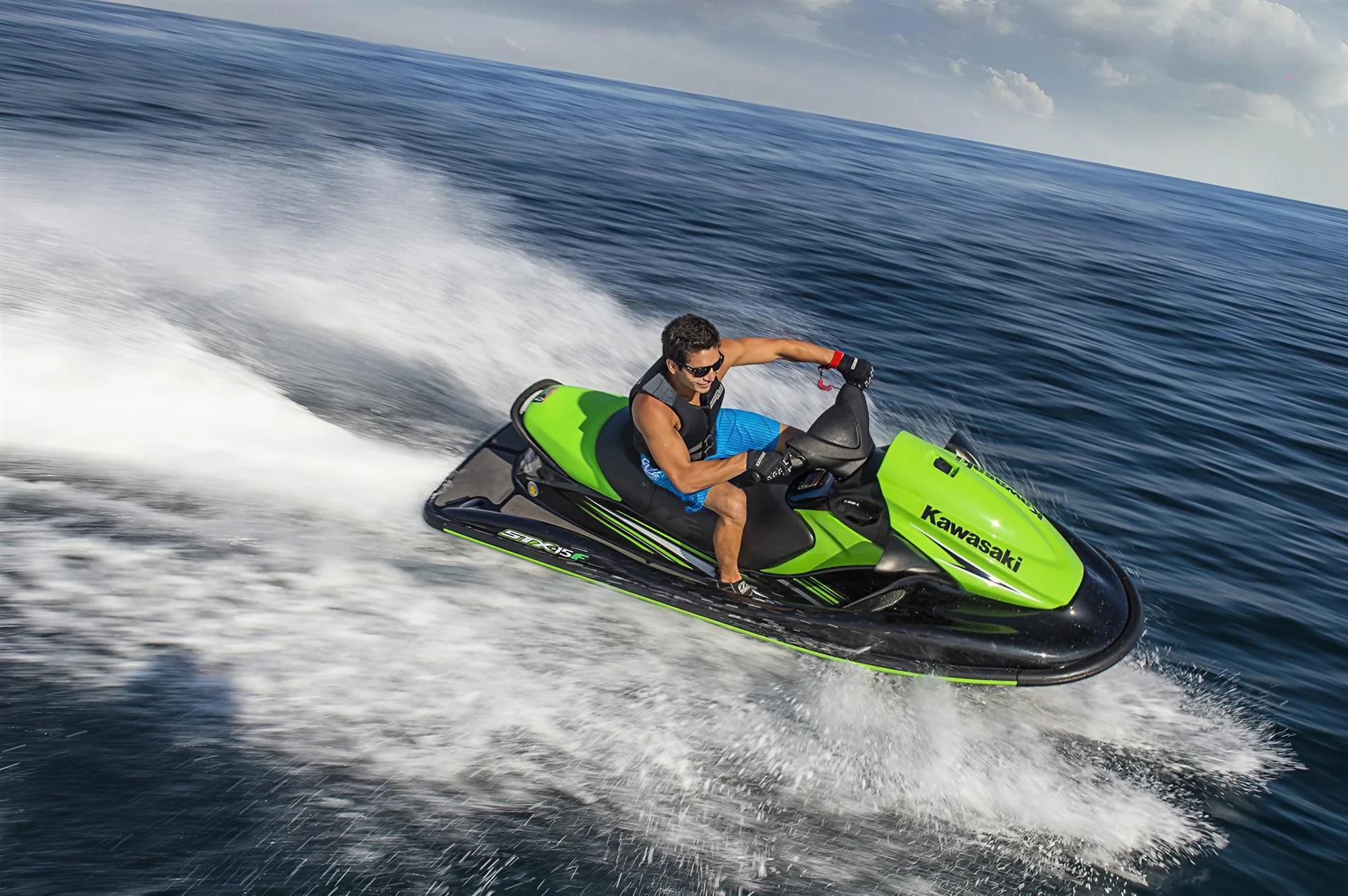 Rider speeding on a green jet ski across open water