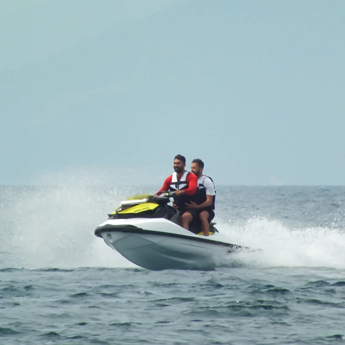 Two riders on a jet ski on open water