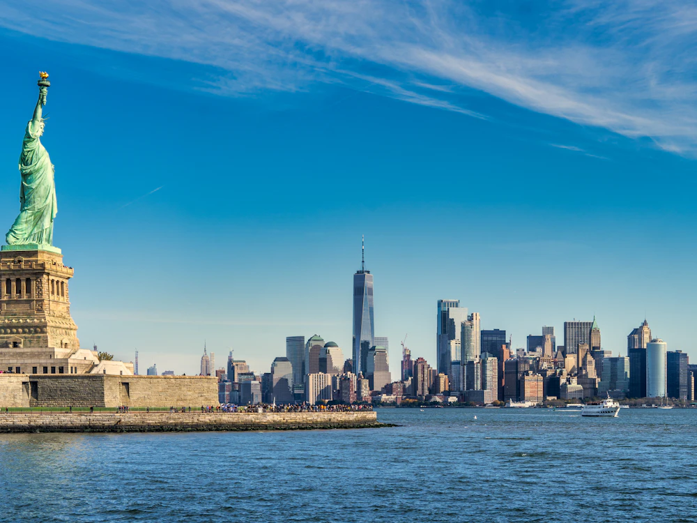 Statue of Liberty with the Lower Manhattan skyline across the harbor