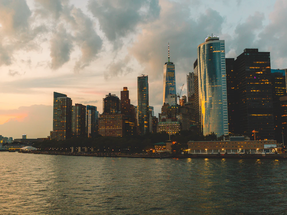 Lower Manhattan towers glowing at sunset over the water